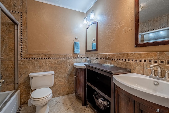 full bathroom with vanity, toilet, tile walls, and ornamental molding