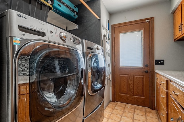 washroom with light tile patterned floors, cabinets, and independent washer and dryer