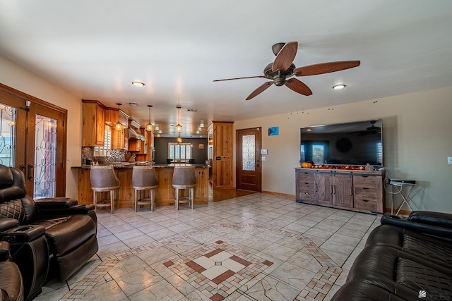 tiled living room with french doors and ceiling fan