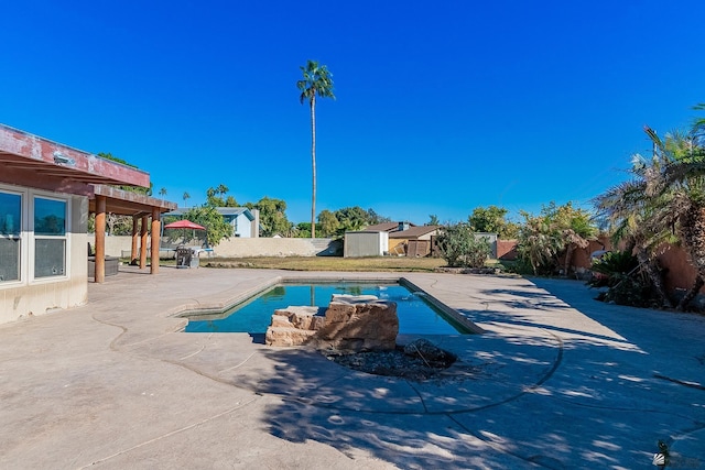 view of pool featuring a patio and a shed