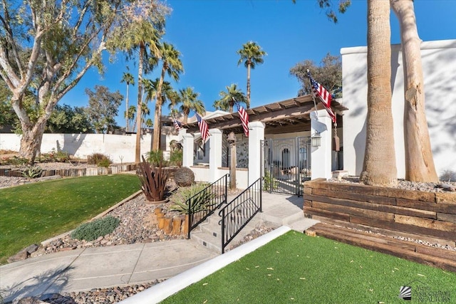 view of front of house with a gate, fence, and a front lawn