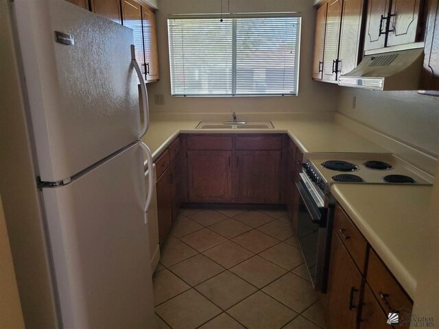 kitchen featuring range with electric cooktop, sink, exhaust hood, white fridge, and light tile patterned flooring