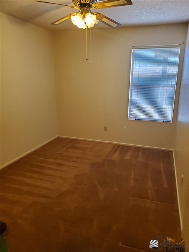 carpeted empty room with ceiling fan and a textured ceiling