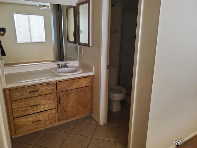 bathroom featuring tile patterned flooring, vanity, and toilet