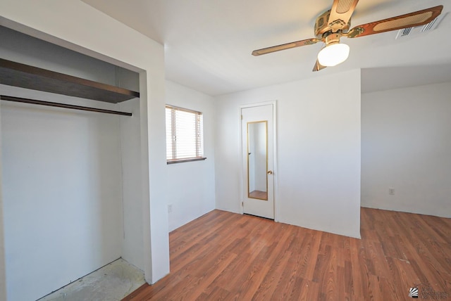 unfurnished bedroom with ceiling fan, dark wood-type flooring, a closet, and visible vents