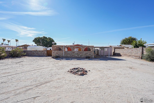 view of front of house featuring a fire pit, a storage shed, an outbuilding, and fence