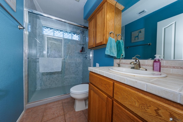 bathroom with an enclosed shower, vanity, tile patterned floors, and toilet