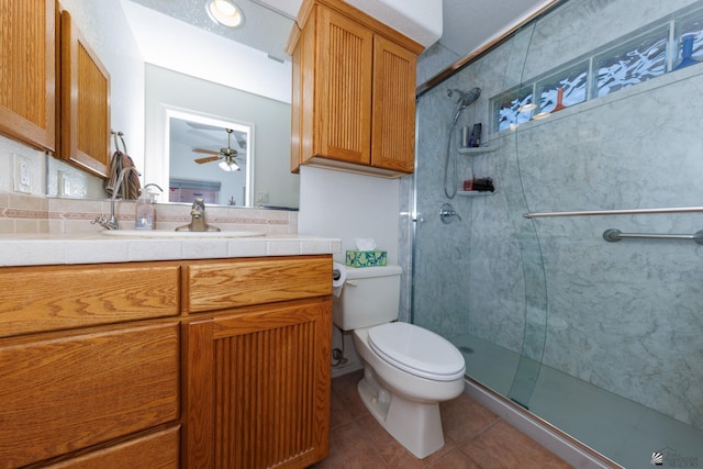 bathroom featuring ceiling fan, vanity, an enclosed shower, tile patterned floors, and toilet