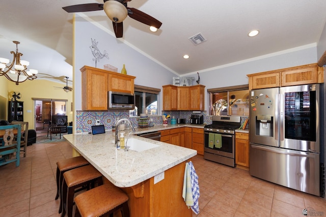 kitchen with sink, a breakfast bar area, decorative light fixtures, kitchen peninsula, and stainless steel appliances