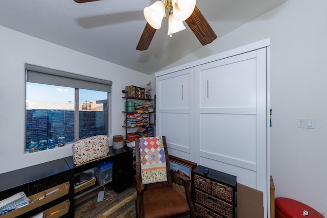 sitting room with dark wood-type flooring, ceiling fan, and vaulted ceiling