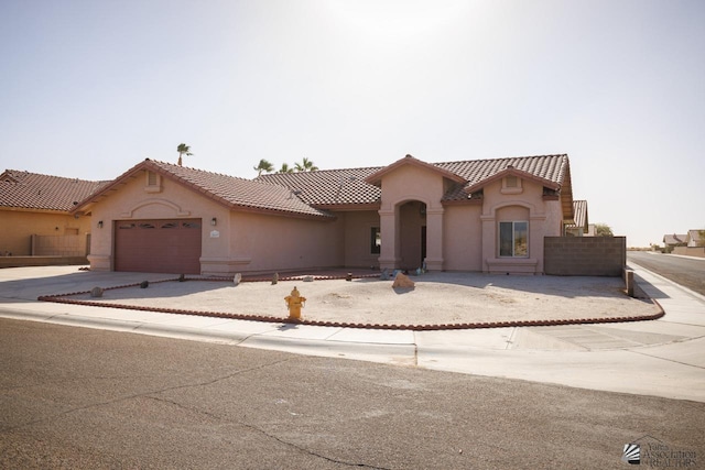 mediterranean / spanish-style house with a garage