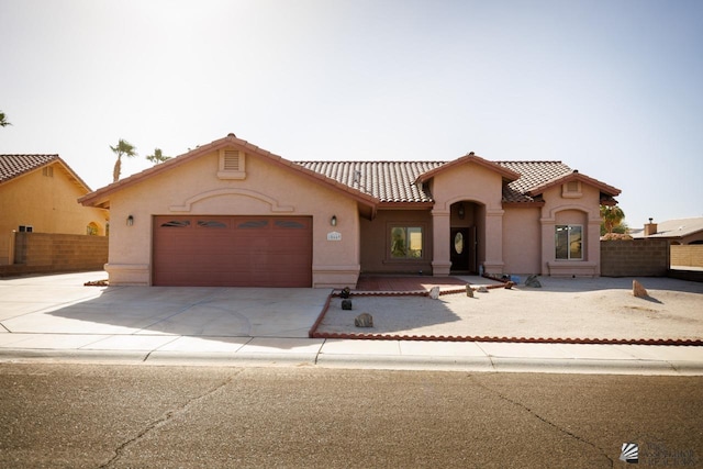 mediterranean / spanish-style house with a garage