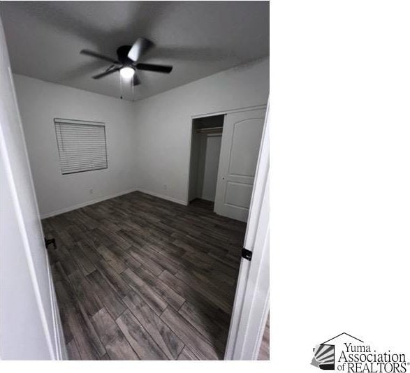 unfurnished bedroom with ceiling fan, dark hardwood / wood-style flooring, and a closet