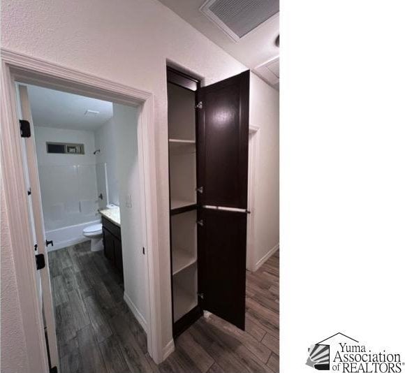 full bathroom with vanity, toilet, shower / bath combination, and hardwood / wood-style floors