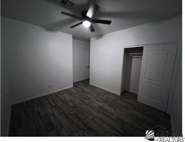 unfurnished bedroom featuring dark wood-type flooring, a closet, and ceiling fan