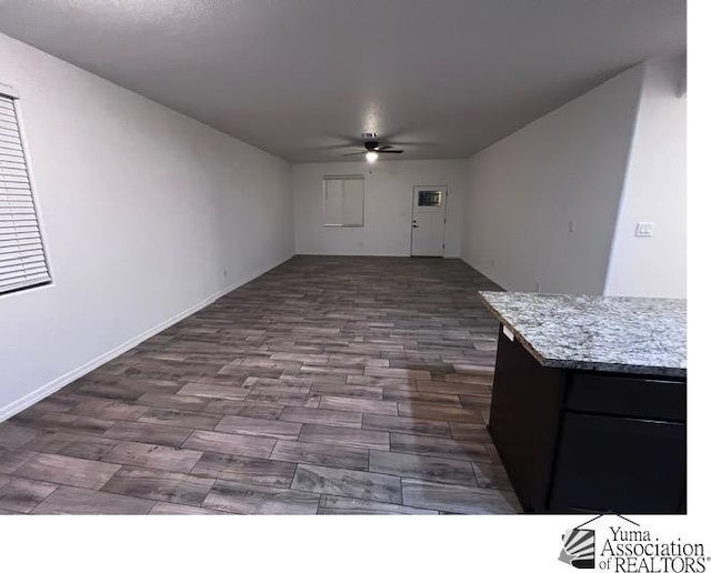 unfurnished living room with dark wood-type flooring and ceiling fan