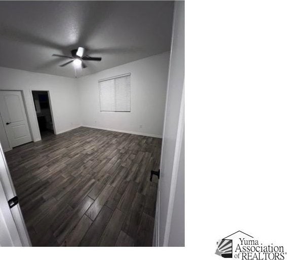 unfurnished bedroom featuring dark hardwood / wood-style flooring and ceiling fan