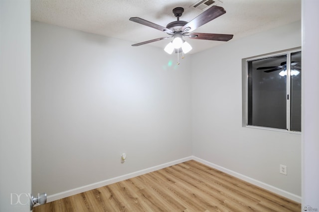 spare room featuring light hardwood / wood-style floors and a textured ceiling