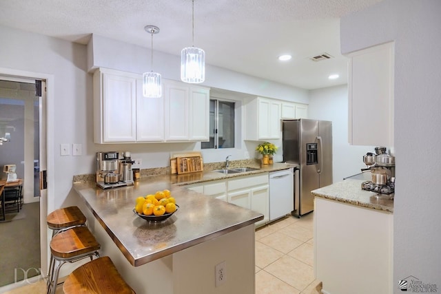 kitchen featuring white dishwasher, a kitchen bar, stainless steel fridge with ice dispenser, and white cabinets