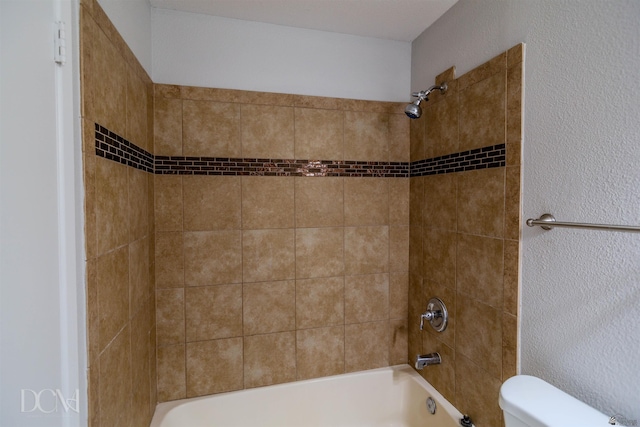 bathroom with tiled shower / bath and toilet