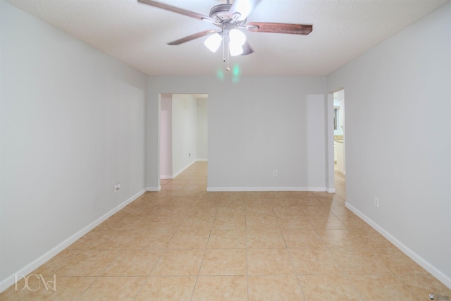 unfurnished room with ceiling fan, light tile patterned floors, and a textured ceiling