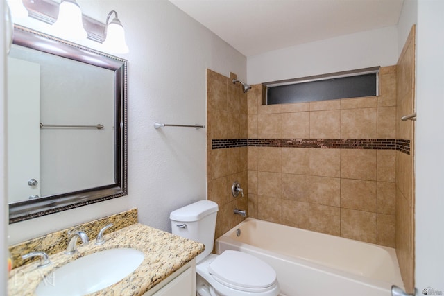 full bathroom with tiled shower / bath combo, toilet, and vanity