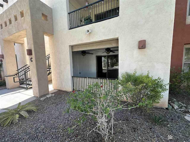 doorway to property with ceiling fan and a balcony