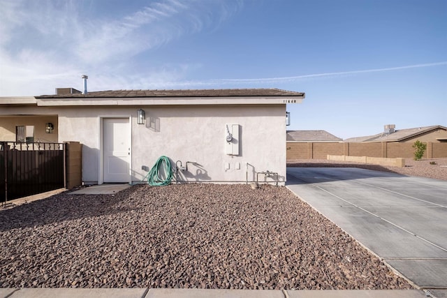 back of property featuring fence and stucco siding