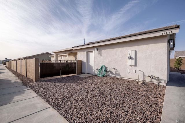 view of home's exterior featuring fence and stucco siding