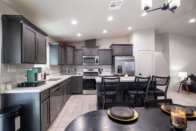 kitchen featuring visible vents, light countertops, stainless steel appliances, a sink, and light tile patterned flooring