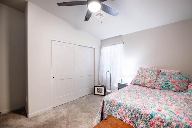 bedroom featuring light carpet, visible vents, lofted ceiling, ceiling fan, and a closet