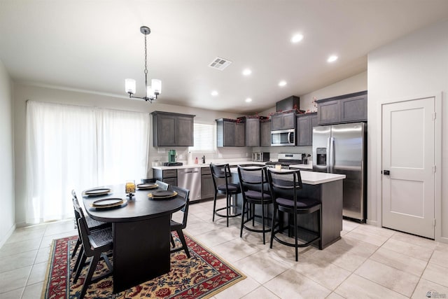 dining area featuring a chandelier, light tile patterned flooring, recessed lighting, visible vents, and vaulted ceiling