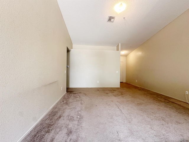 carpeted empty room featuring a textured ceiling