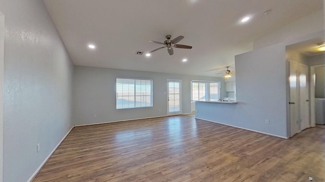 unfurnished living room with lofted ceiling, wood finished floors, a ceiling fan, and recessed lighting