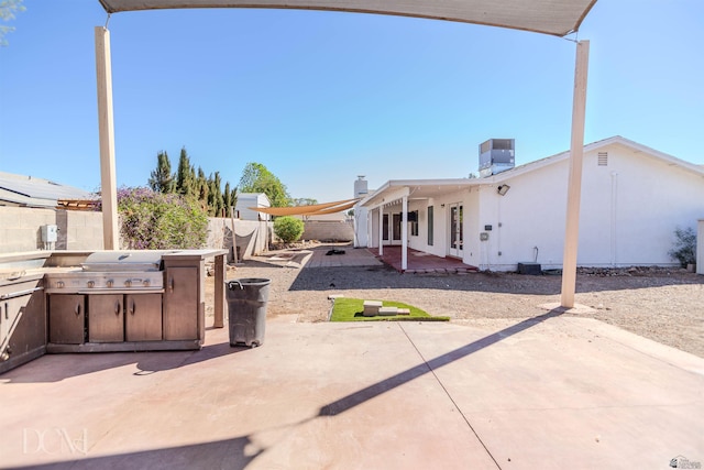 view of patio with exterior kitchen, a fenced backyard, and central AC