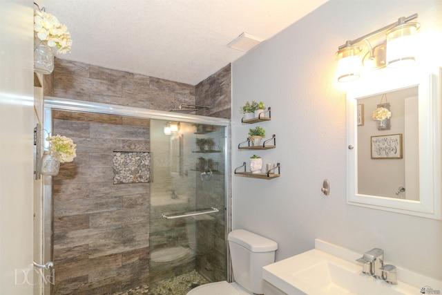 full bathroom featuring visible vents, a shower stall, toilet, and vanity