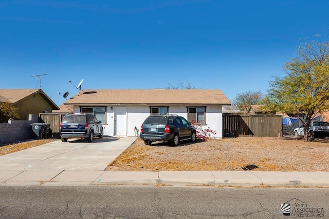 ranch-style house featuring fence