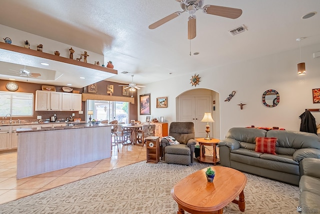 living room with sink, ceiling fan, and light tile patterned floors