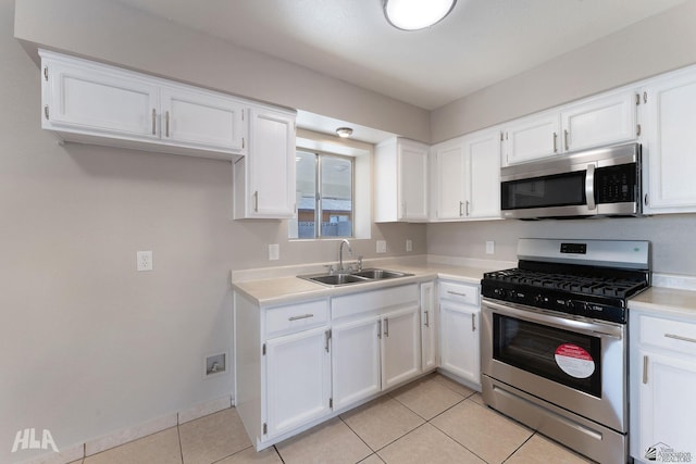 kitchen with sink, white cabinets, stainless steel appliances, and light tile patterned floors