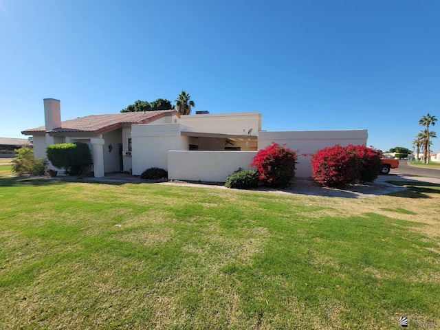 view of front of house featuring a front yard, a tiled roof, and stucco siding