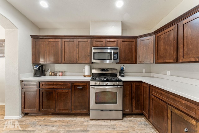 kitchen with stainless steel appliances and dark brown cabinetry