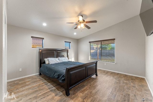 bedroom with hardwood / wood-style floors, vaulted ceiling, and ceiling fan