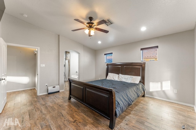 bedroom with multiple windows, hardwood / wood-style floors, and ceiling fan