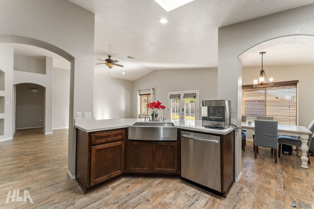 kitchen with sink, light hardwood / wood-style flooring, a textured ceiling, pendant lighting, and stainless steel appliances