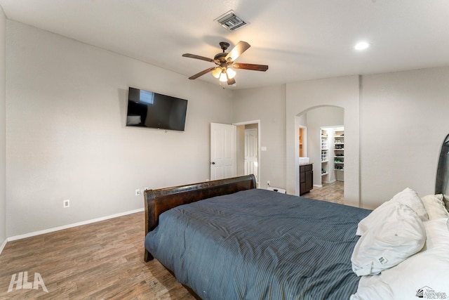 bedroom with ceiling fan, a spacious closet, and hardwood / wood-style floors