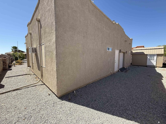 view of side of home with a shed