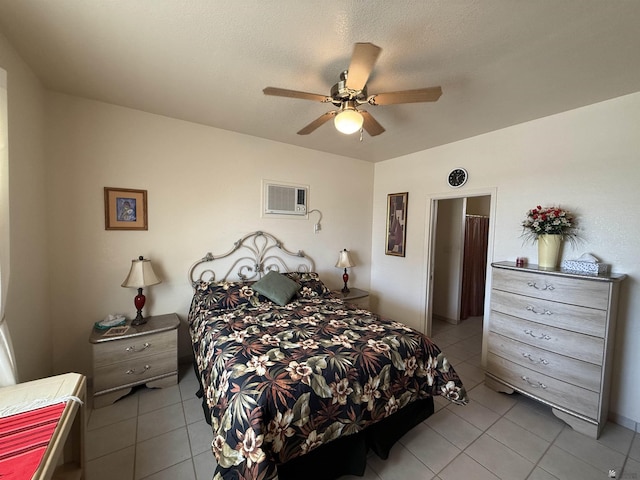 bedroom with a wall mounted air conditioner, light tile patterned floors, a textured ceiling, and ceiling fan