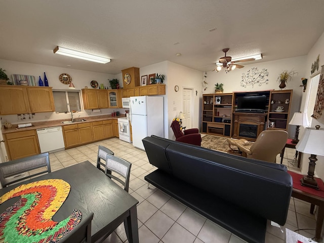 living room with light tile patterned flooring, a textured ceiling, ceiling fan, and sink