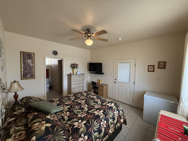 bedroom with ensuite bath, ceiling fan, light tile patterned floors, and refrigerator