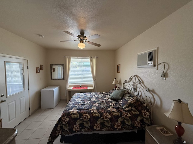 bedroom with refrigerator, an AC wall unit, ceiling fan, a textured ceiling, and light tile patterned flooring